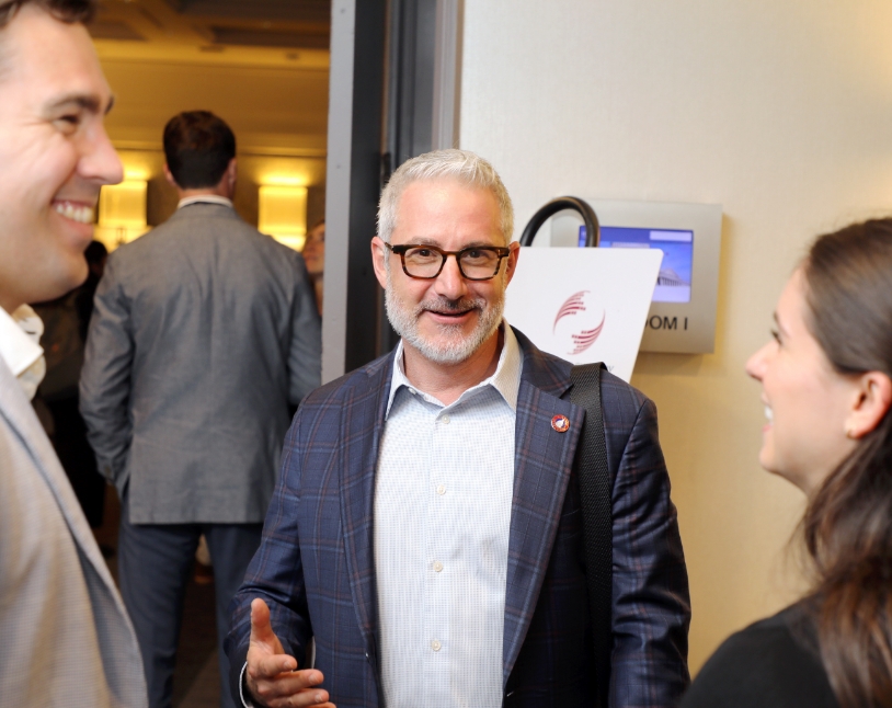 Interacting with colleagues during a professional meeting.